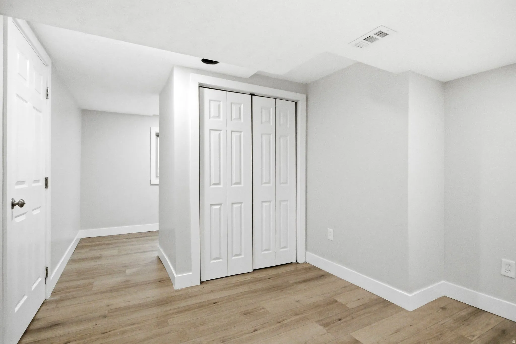Recessed lighting illuminates wood-finish flooring throughout this interior space