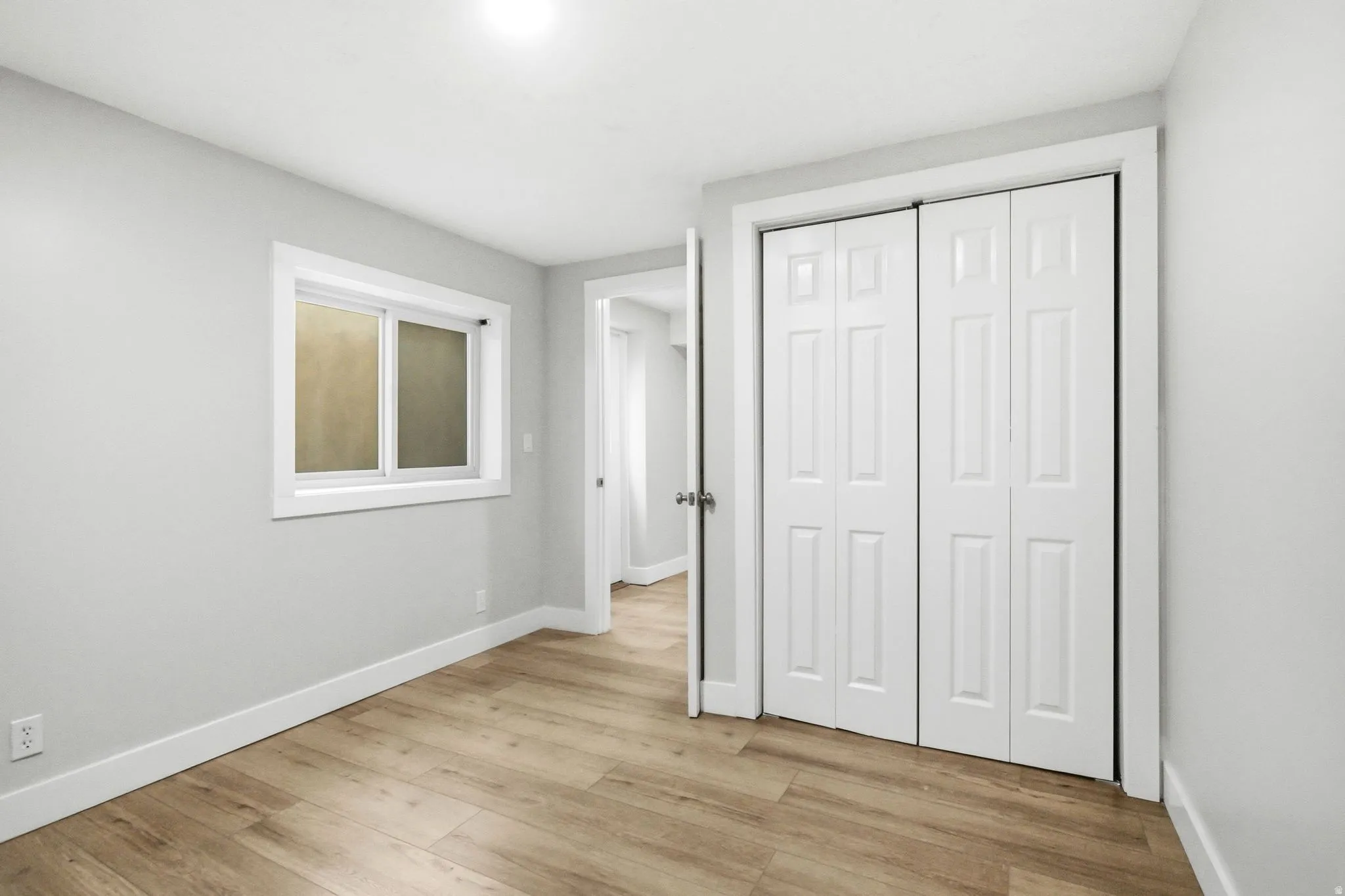 Light wood-finish flooring complements the neutral wall color