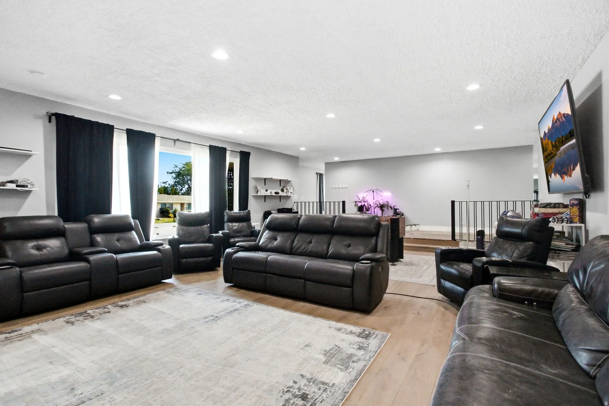 Spacious living area featuring wood-finish flooring and recessed lighting
