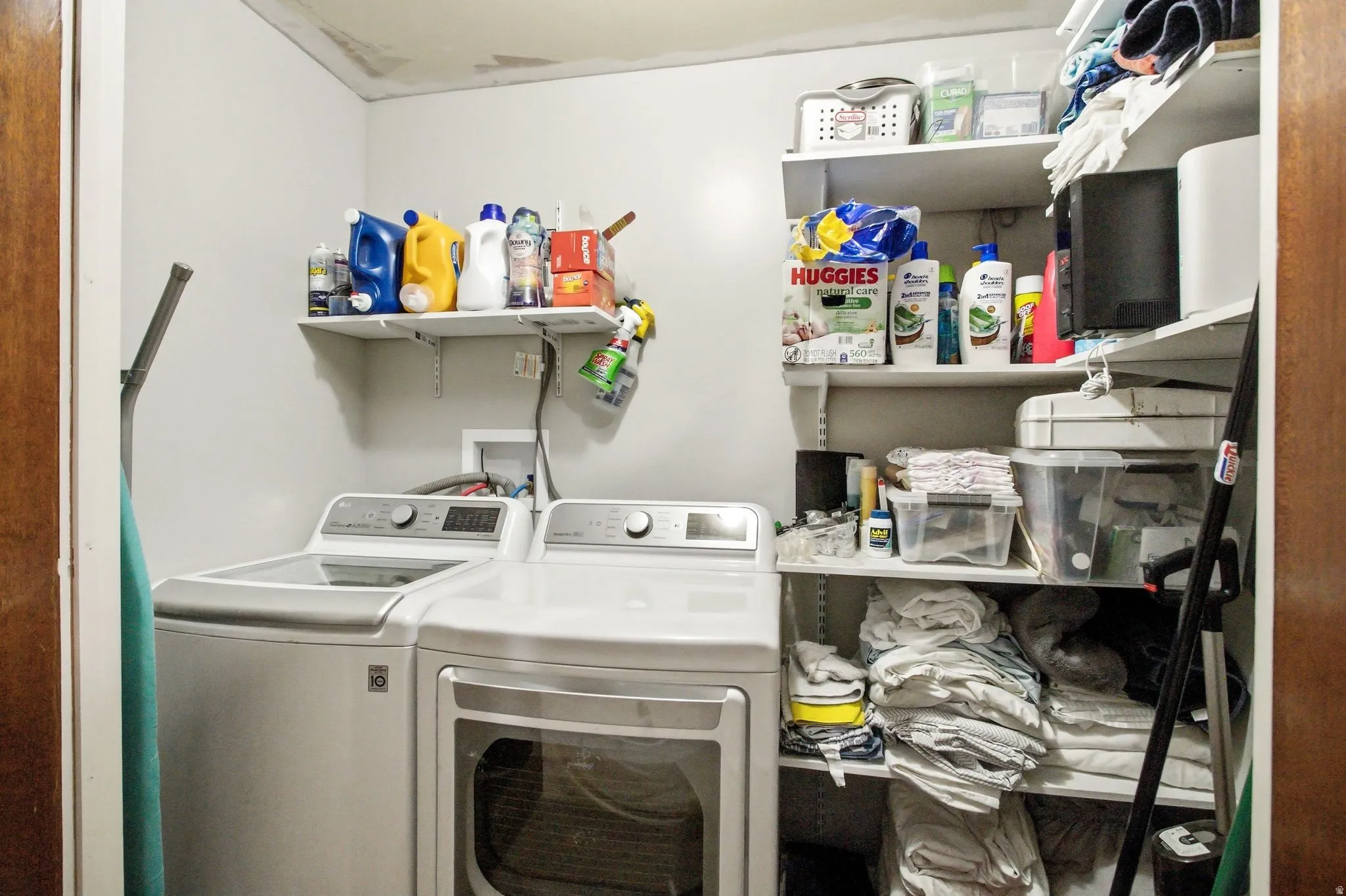Dedicated laundry space featuring a white top-load washing machine and front-load dryer