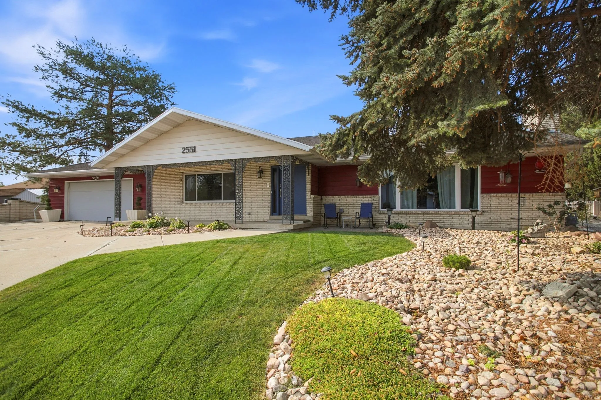 Ranch-style residence featuring a brick and siding exterior, an attached garage, and a concrete driveway