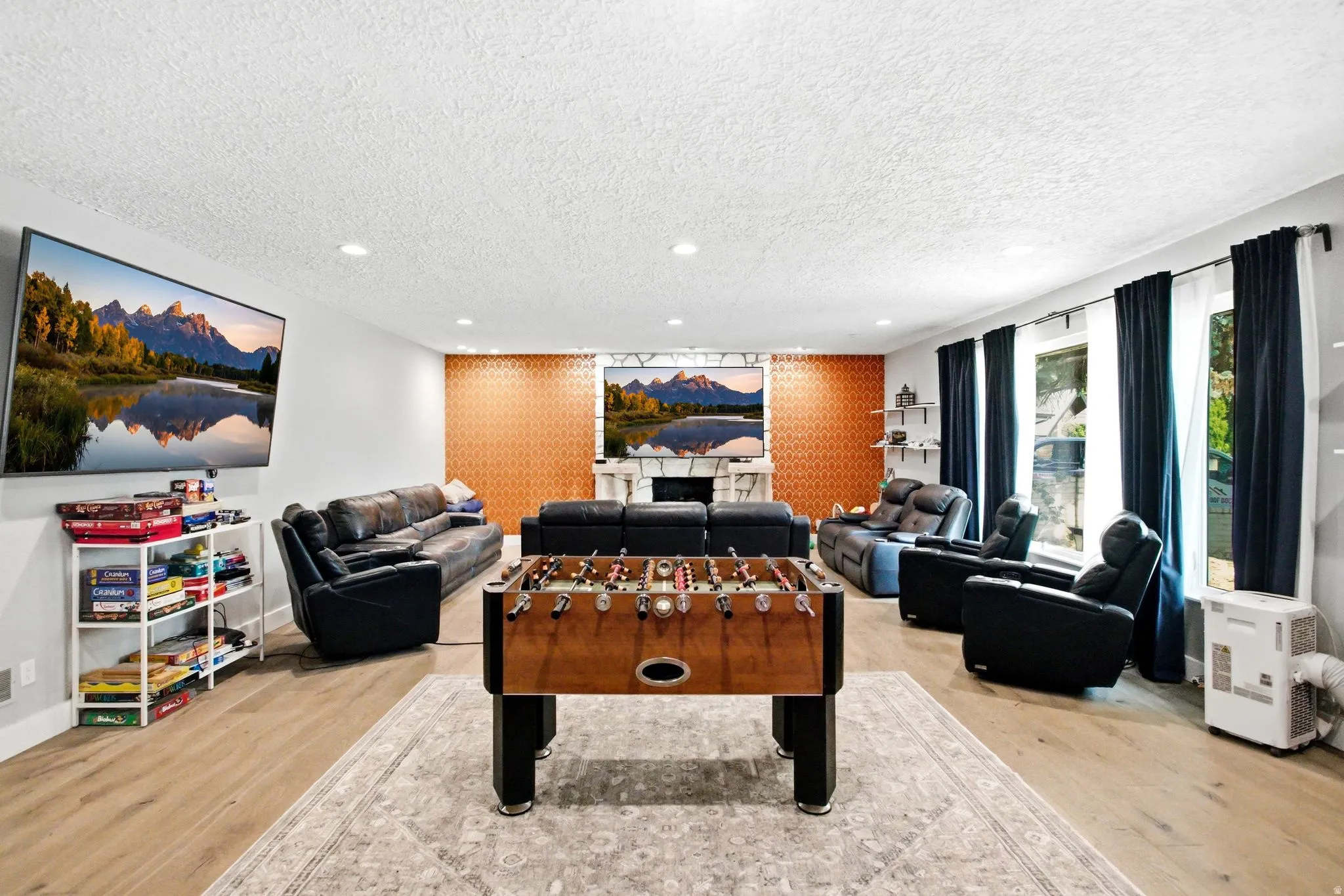 Spacious entertainment room featuring wood-finish flooring and recessed lighting