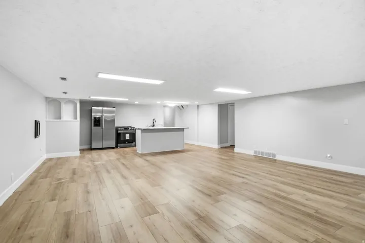 Open-concept living space featuring wood-finish flooring, recessed lighting, and a neutral color palette
