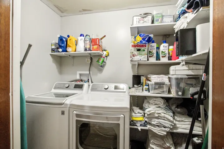 Dedicated laundry space featuring a white top-load washing machine and front-load dryer