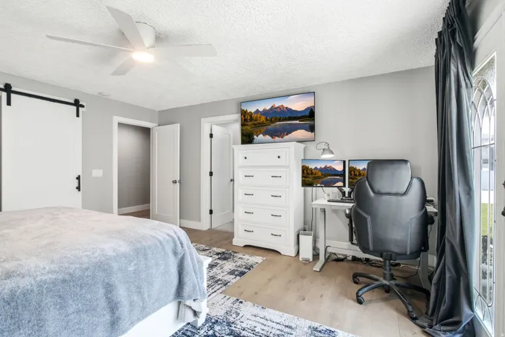 Light-toned wood-finish flooring complements the neutral wall color