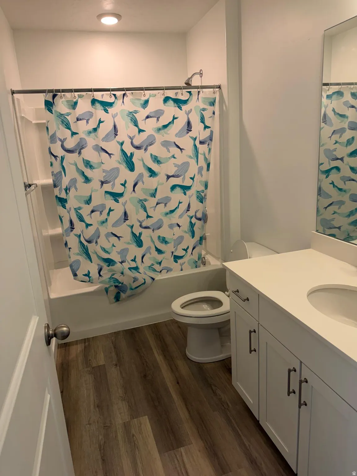 Bathroom featuring a white vanity with an integrated sink, white countertop, and dark hardware