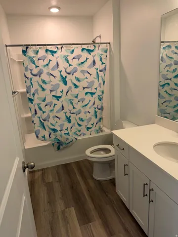 Bathroom featuring a white vanity with an integrated sink, white countertop, and dark hardware