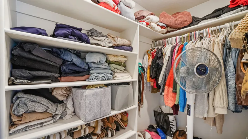 Custom closet system featuring built-in shelving, hanging rods, and corner storage