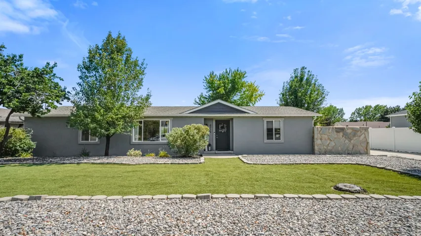 Ranch-style residence featuring a gray exterior finish and stone accent wall
