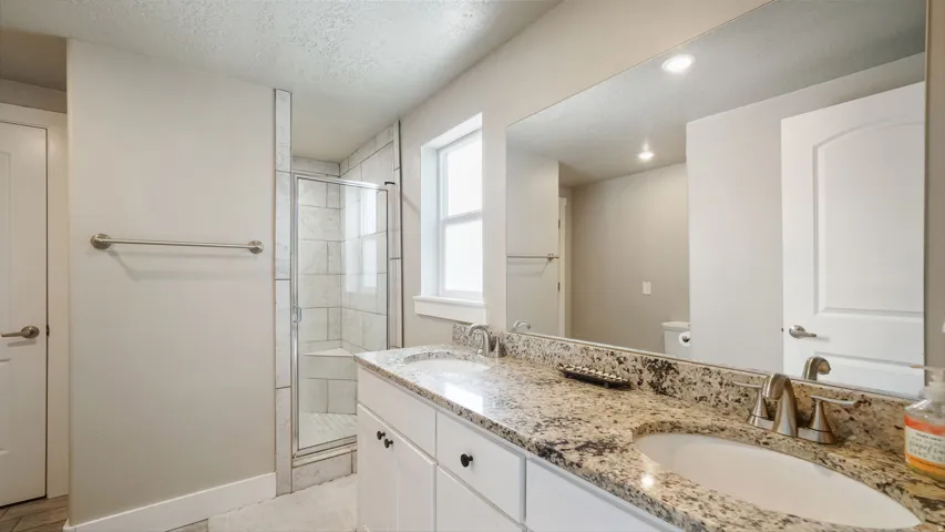 Dual vanity with granite countertop, undermount sinks, and brushed nickel fixtures