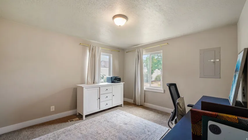 Neutral wall paint, ceiling-mounted light fixture, and two windows with white trim
