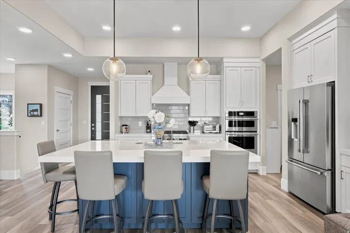 Modern kitchen featuring a large central island with a contrasting blue base and white countertop