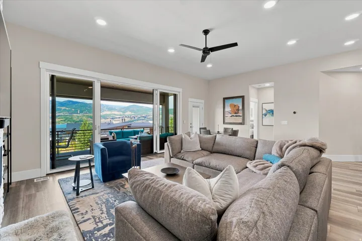Open-concept living area featuring a multi-panel sliding glass door system, recessed lighting, and a modern ceiling fan