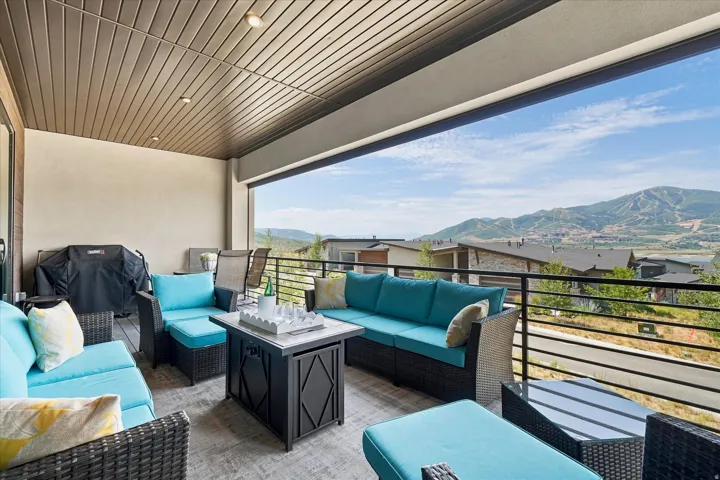 Covered outdoor patio featuring a slat ceiling, recessed lighting, and a metal railing