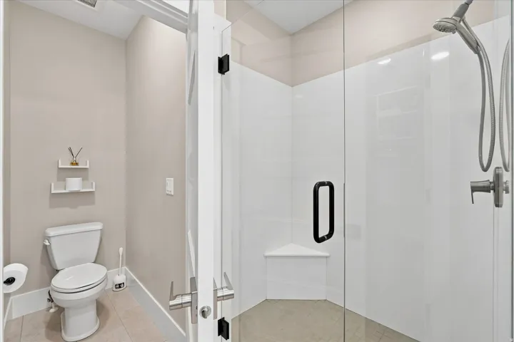 Contemporary walk-in shower with clear glass enclosure and black hardware