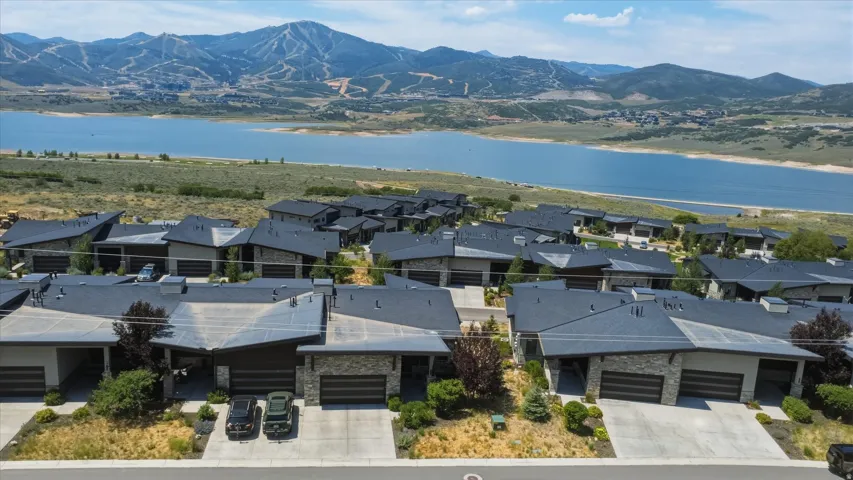 Modern residential development featuring a collection of homes with dark shingle roofs and stone accents