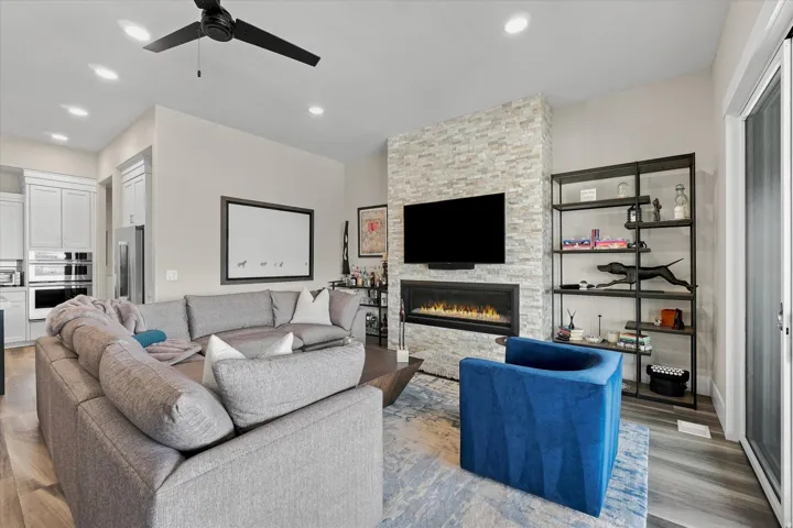 Living area featuring a stone accent wall, linear fireplace, and recessed lighting
