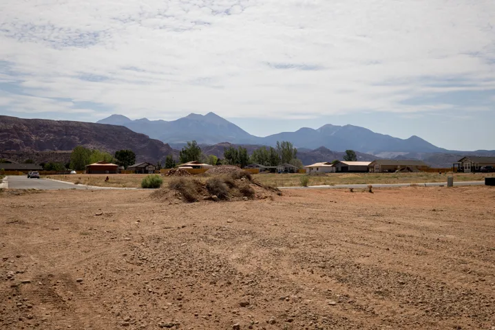 Expansive undeveloped lot featuring a natural earth surface, surrounded by established residences