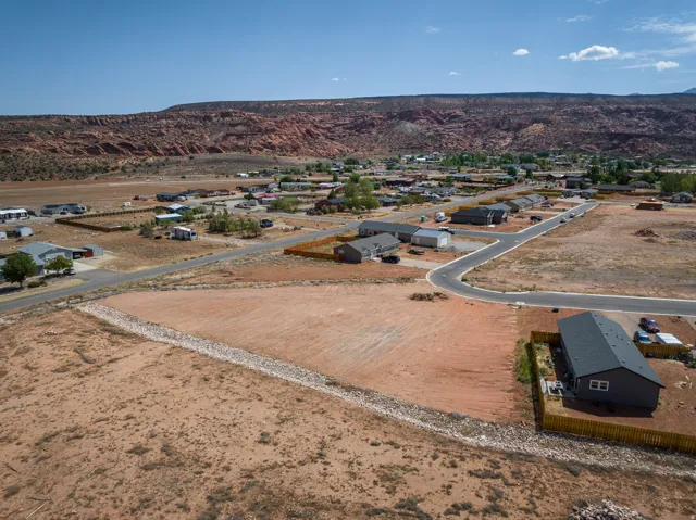 Expansive undeveloped land parcel featuring a gravel drainage channel and direct access to paved roadways