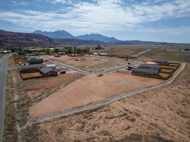 Developing residential area featuring new construction homes, paved roads, and natural desert landscaping