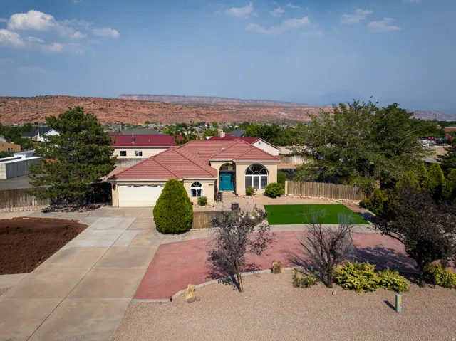 Single-story residence featuring a tile roof, arched windows, and a vibrant turquoise front door