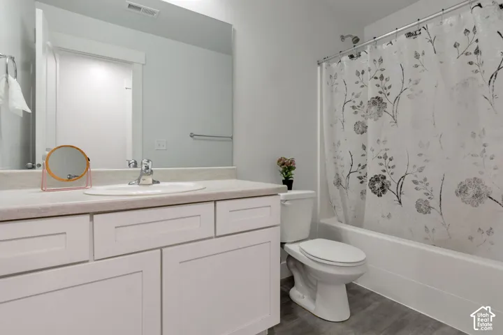 Bathroom featuring a single vanity with light-toned countertop, white cabinetry, and an undermount sink