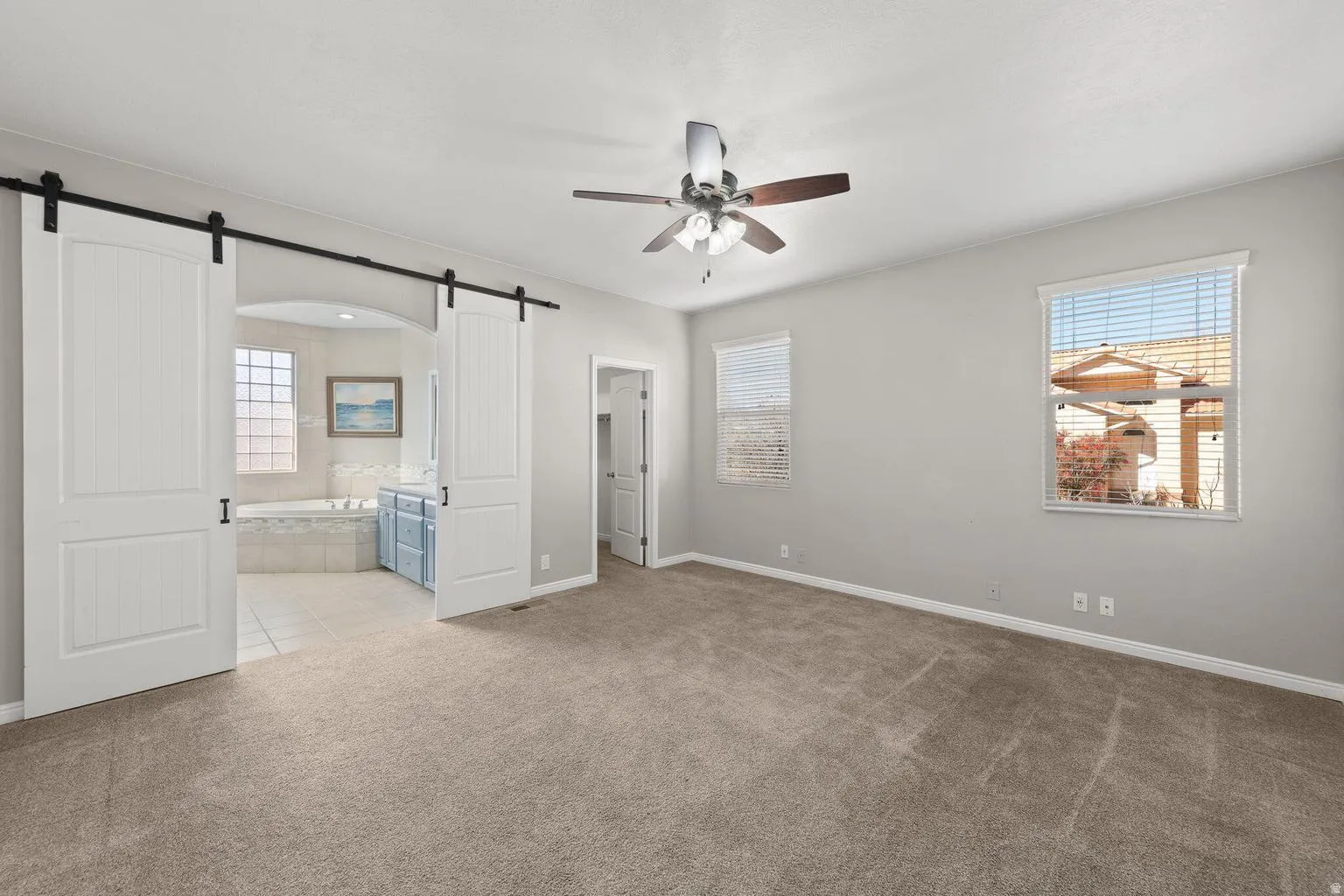 Spacious room featuring neutral carpeting and light gray walls