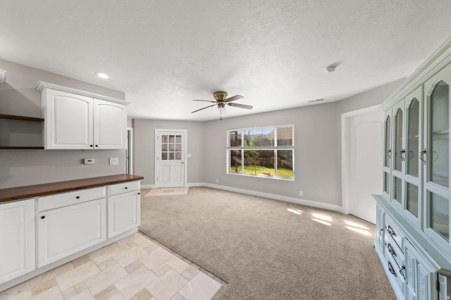 Open-concept living area featuring light gray wall tones, recessed lighting, and a ceiling fan