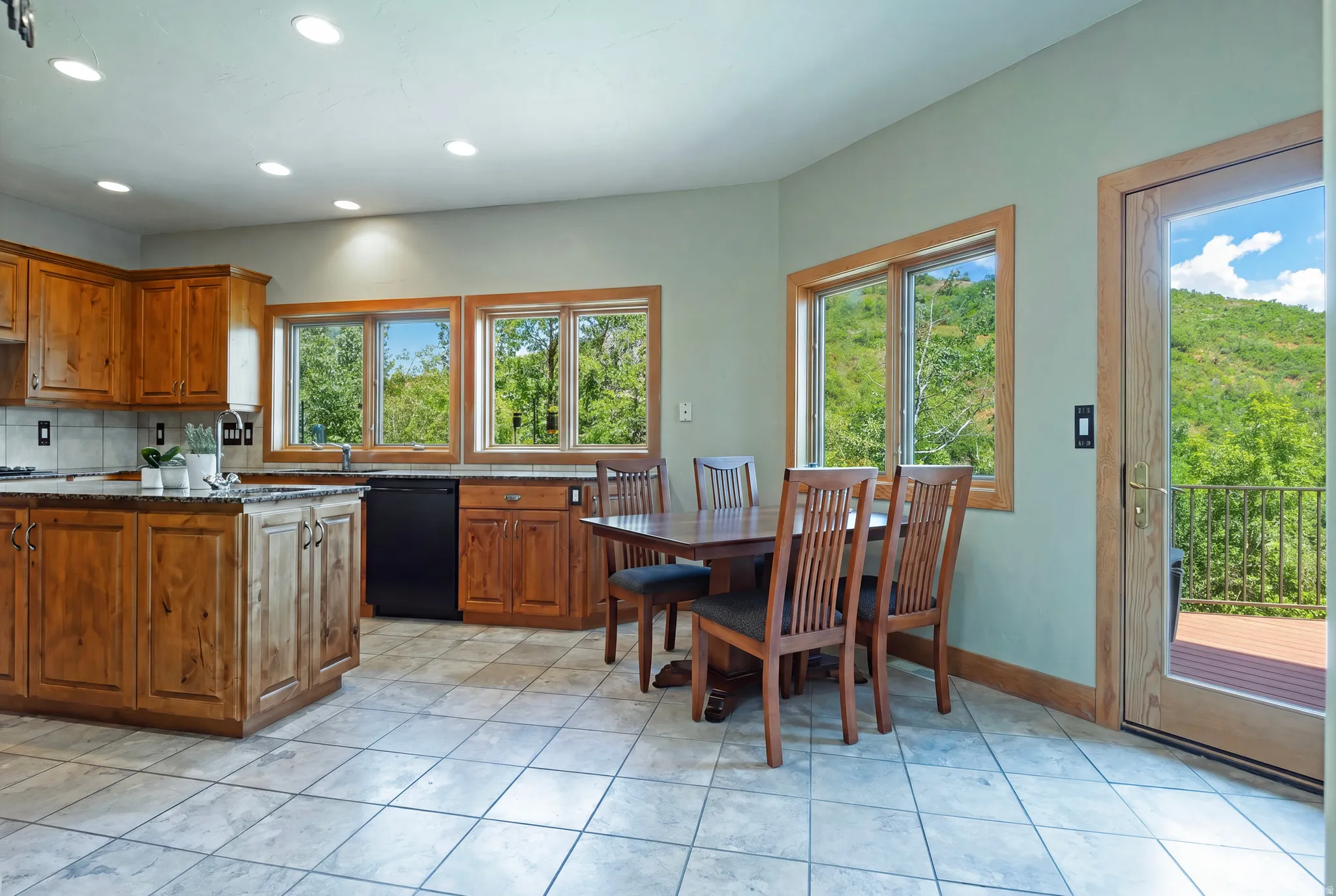 Kitchen and dining area featuring wood cabinetry, granite-style countertops, and a tile backsplash
