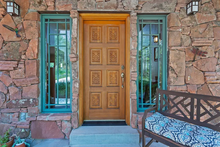 Stone veneer exterior featuring an ornate wood-paneled entry door