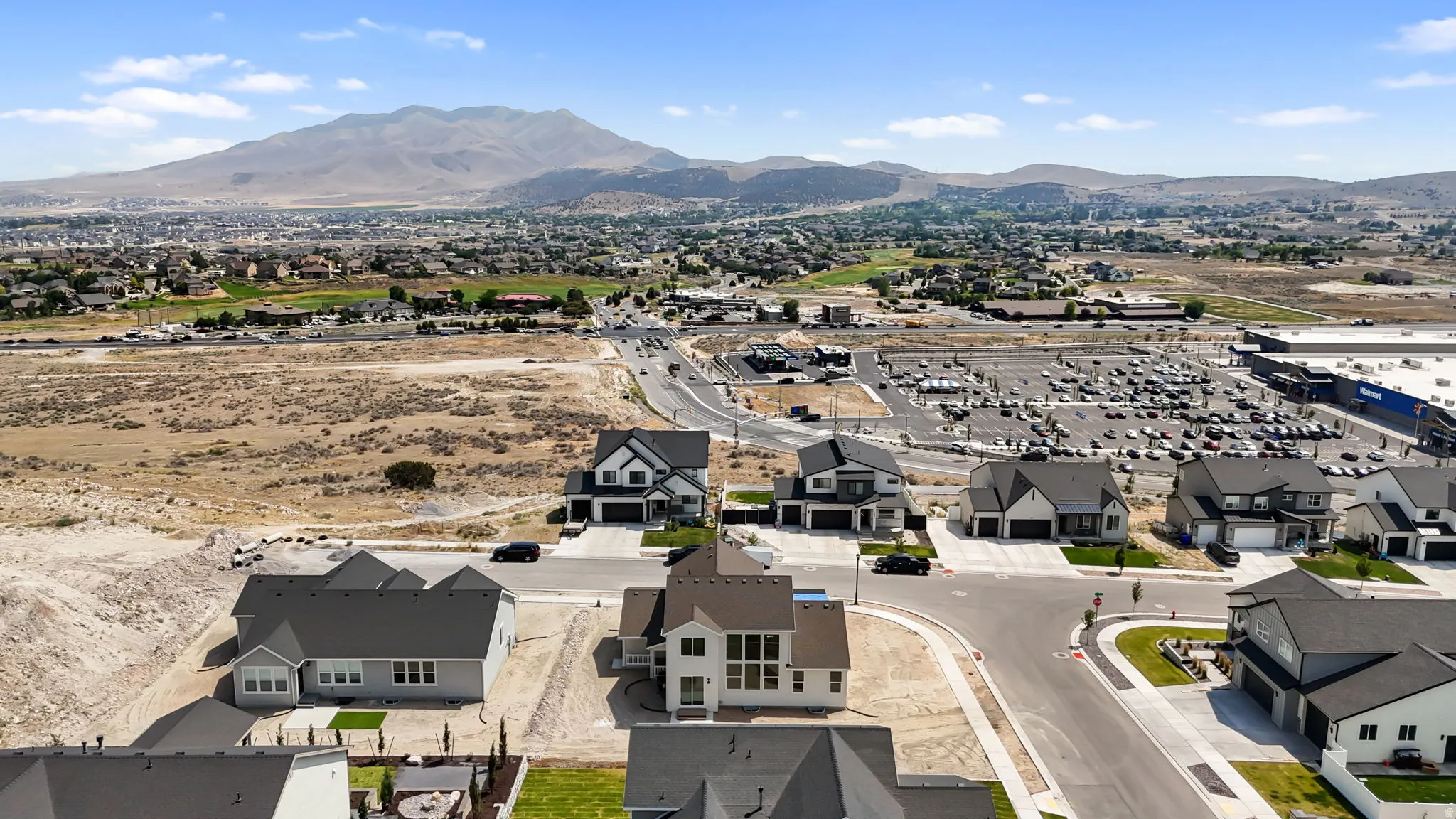 Aerial perspective featuring a neighborhood with contemporary homes against a mountainous backdrop