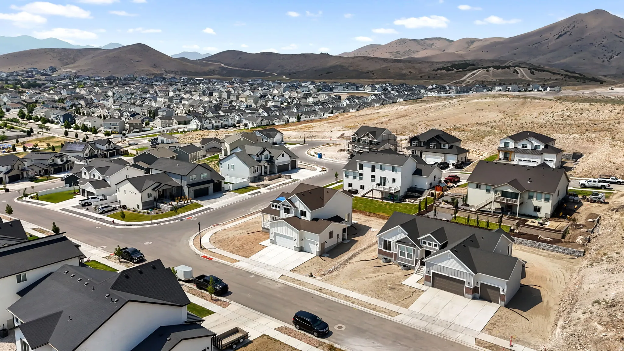 Expansive residential development with contemporary homes featuring varied architectural styles and dark shingle roofs
