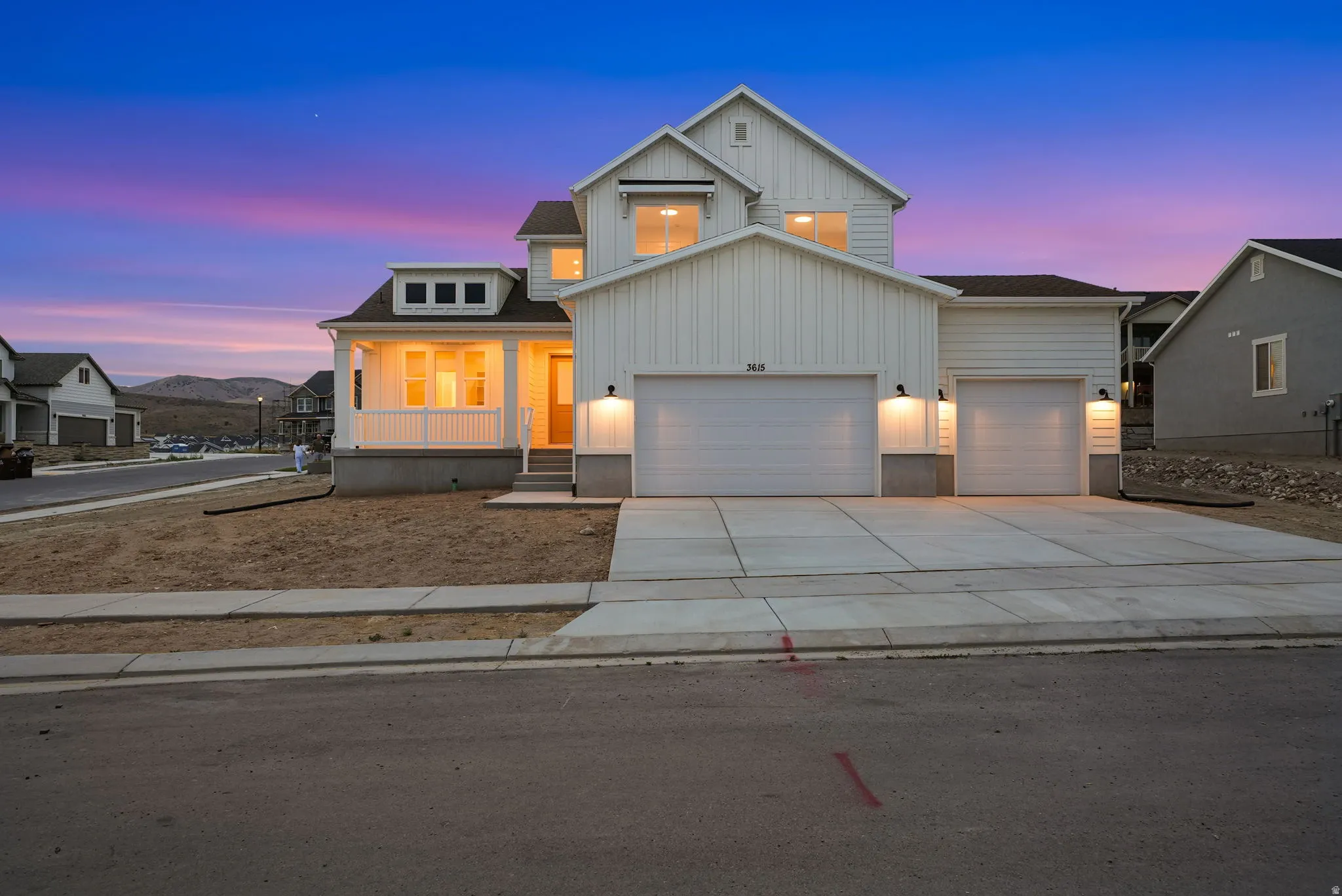 Modern farmhouse-style residence featuring white vertical siding, an inviting front porch with white railings, and a prominent two-car garage