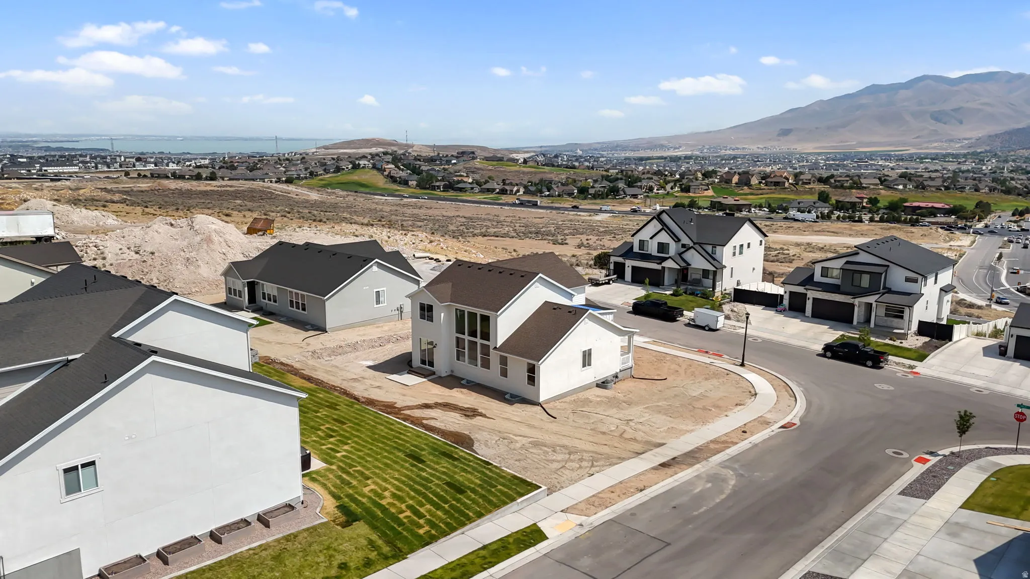 Newly constructed residence featuring a light-colored exterior with dark roofing