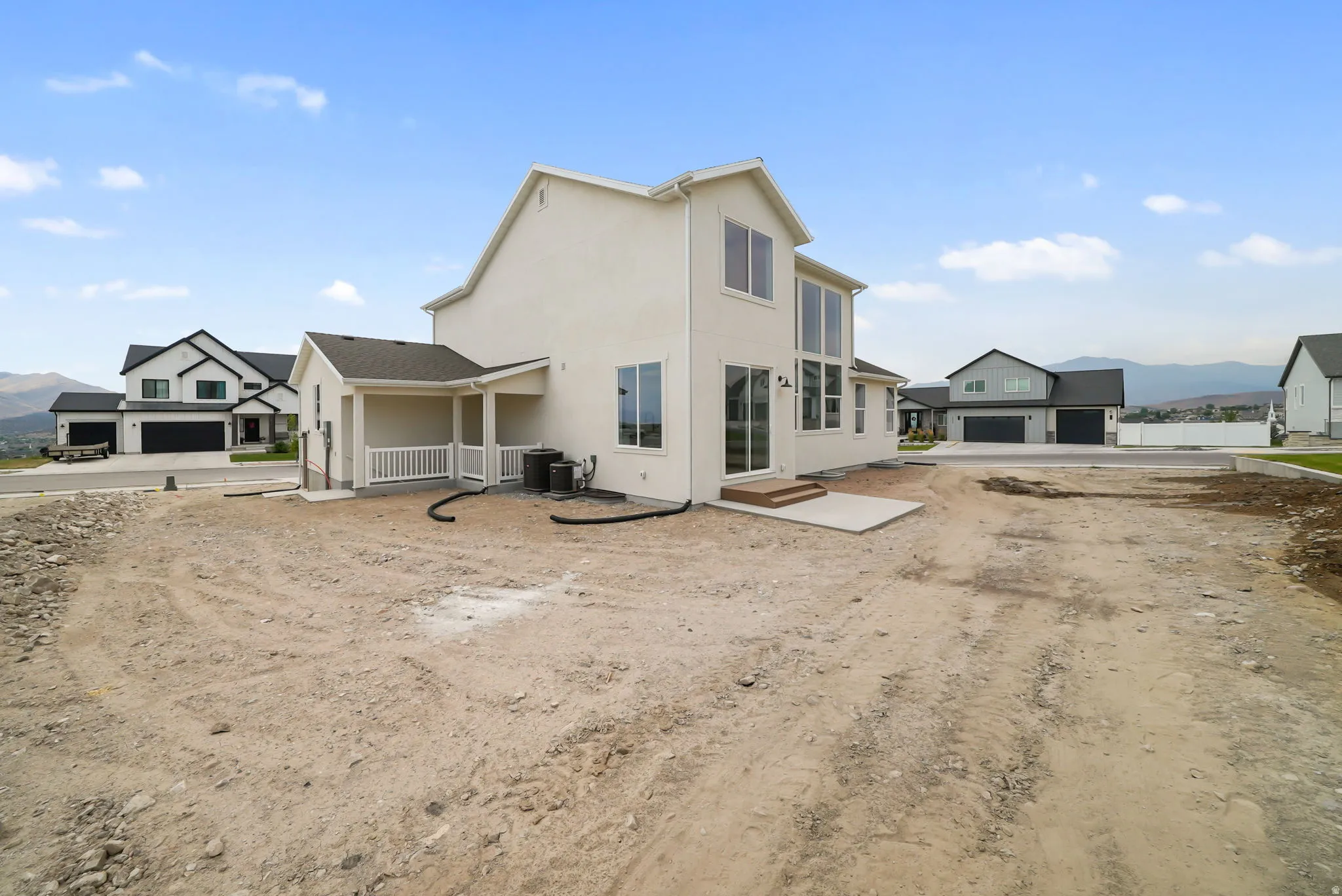Newly constructed residence featuring a light-colored stucco exterior