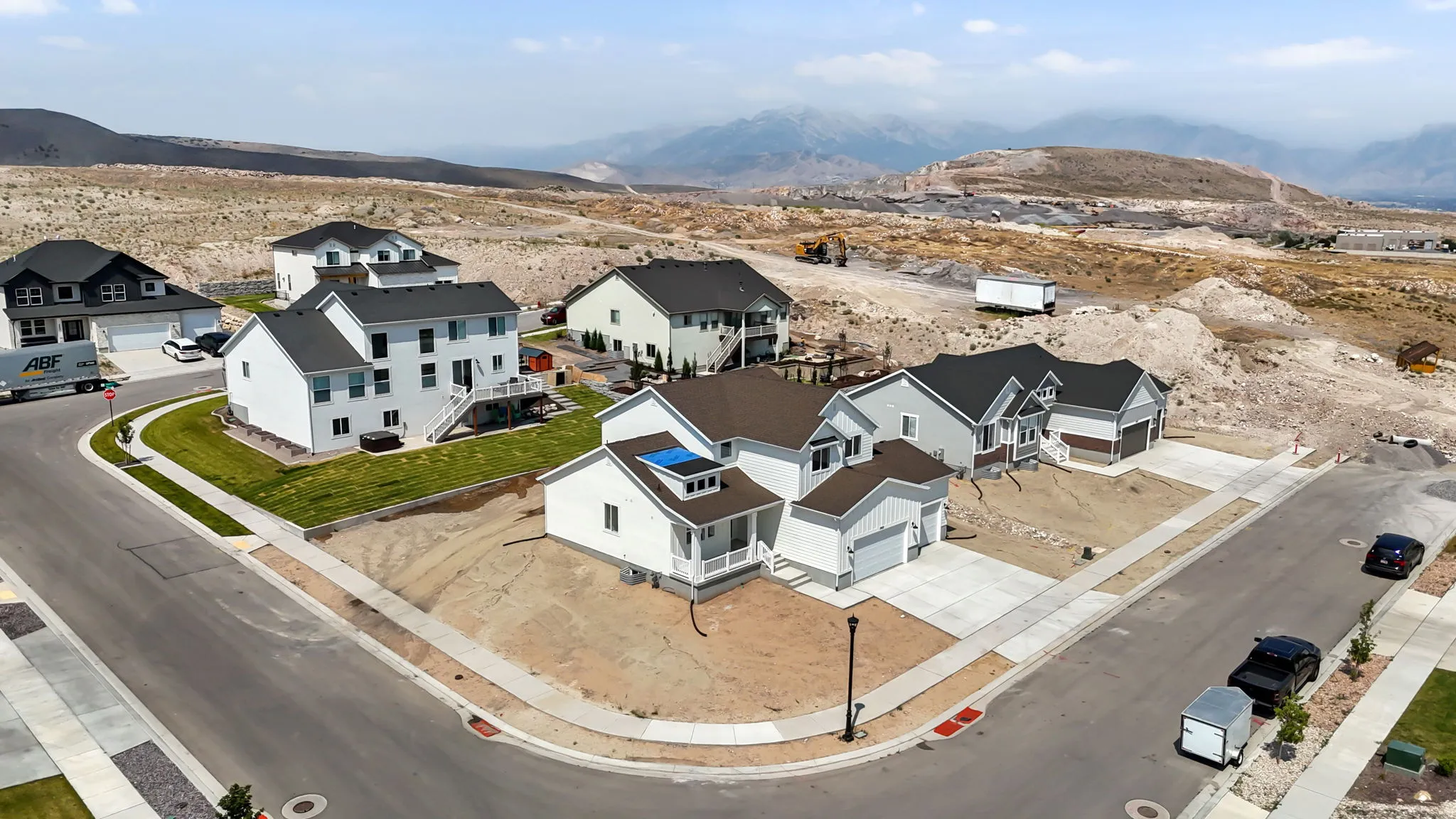 Newly constructed homes featuring two-car garages, light-toned siding, dark roofing, and paved driveways