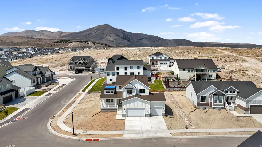 New construction residential properties situated on curved streetscape with mountain backdrop