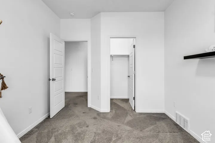 Interior room featuring gray carpet flooring and white walls