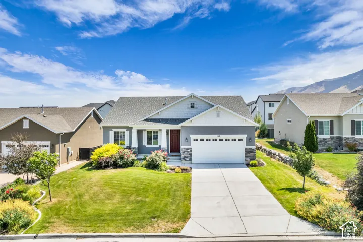 Single-story residence featuring a gray exterior with white trim, a red front door, an attached two-car garage, stone accents, and a concrete driveway
