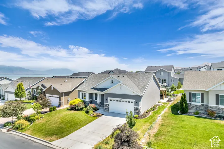 Modern single-story residence featuring a two-car garage, stone and siding exterior, and a manicured front lawn