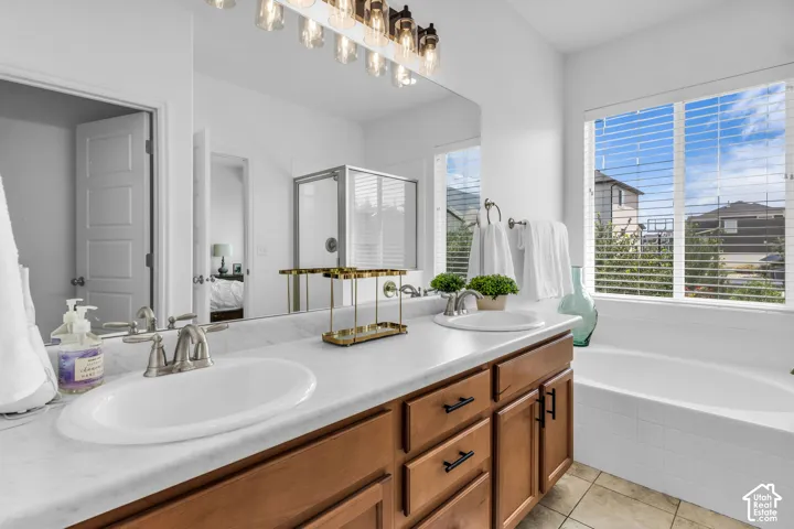 Double vanity with undermount sinks, bronze hardware, and a large integrated mirror