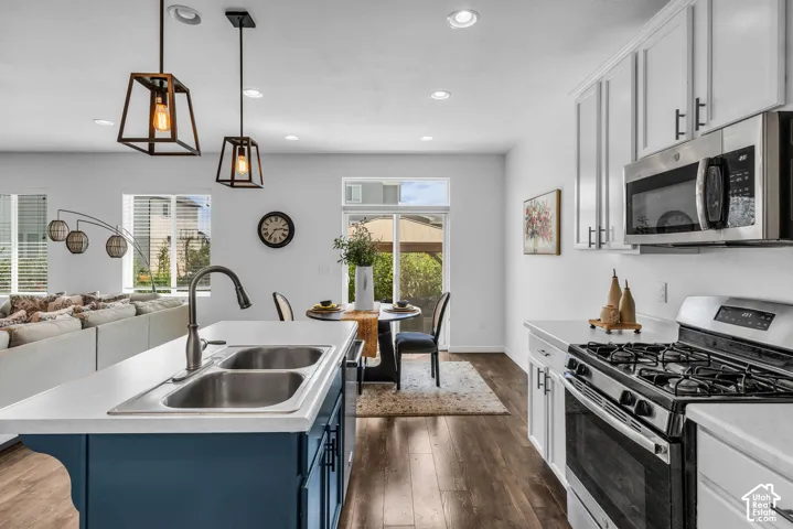 Contemporary kitchen featuring a stainless steel gas range, over-range microwave, and white cabinetry