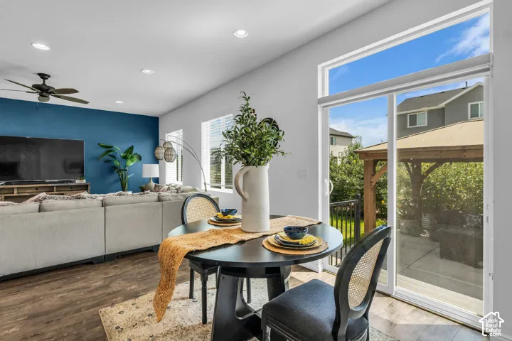 Spacious dining area featuring wood-finish flooring, recessed lighting, and a sliding glass door leading to an outdoor patio with a wooden pergola