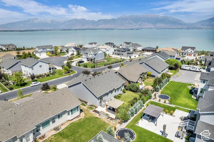 Aerial perspective showcasing a residential community with lakefront properties and mountainous backdrops