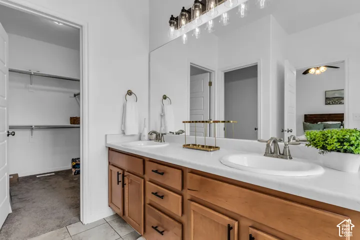 Double vanity with undermount sinks, light countertop, and wood-finish cabinetry