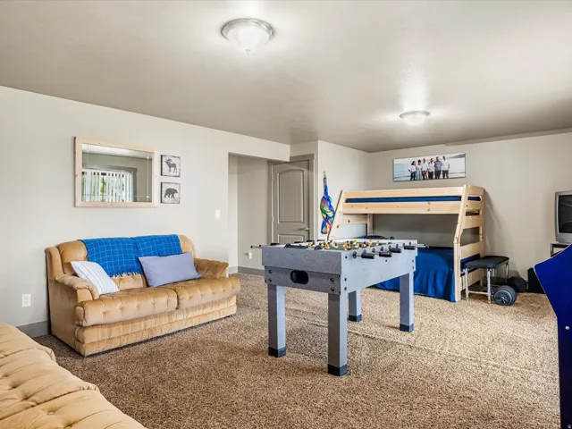 Spacious room featuring neutral wall tones, a textured carpeted floor, and a light-colored ceiling
