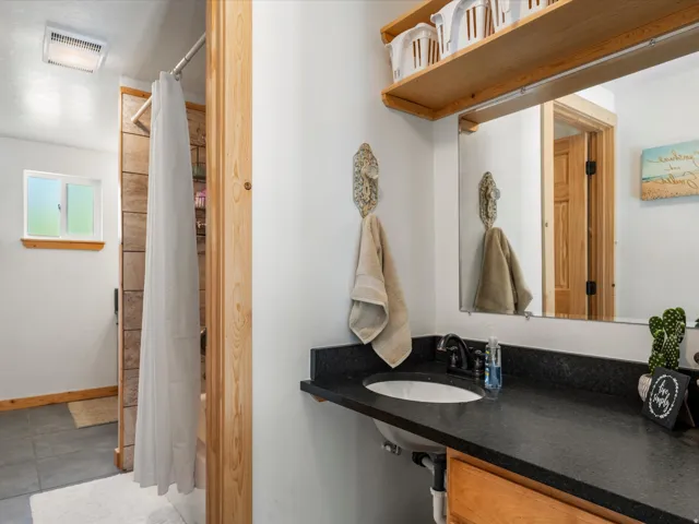 Bathroom vanity featuring a dark countertop, undermount sink, and black faucet