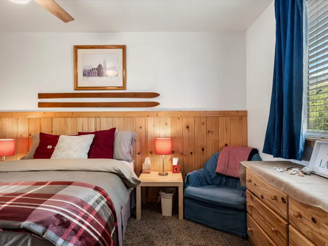 Bedroom featuring wood-paneled wainscoting and a matching pine dresser