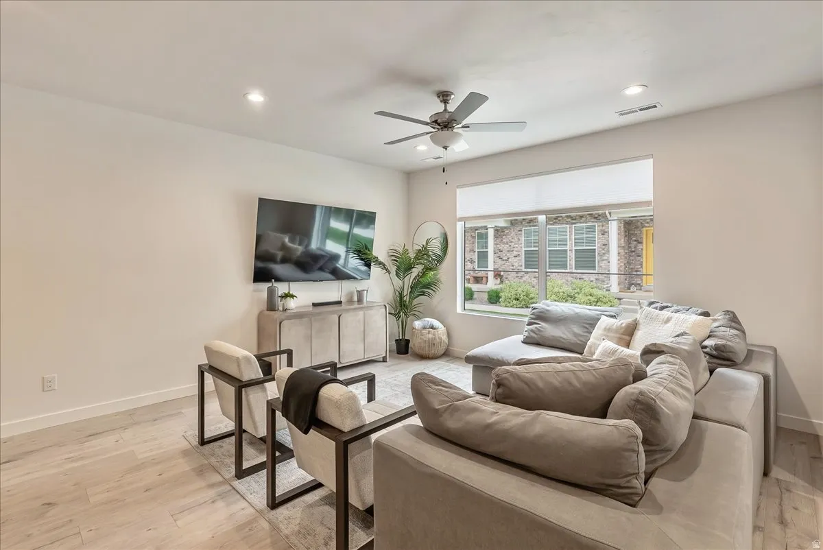 Living area featuring wood-finish flooring and a ceiling fan
