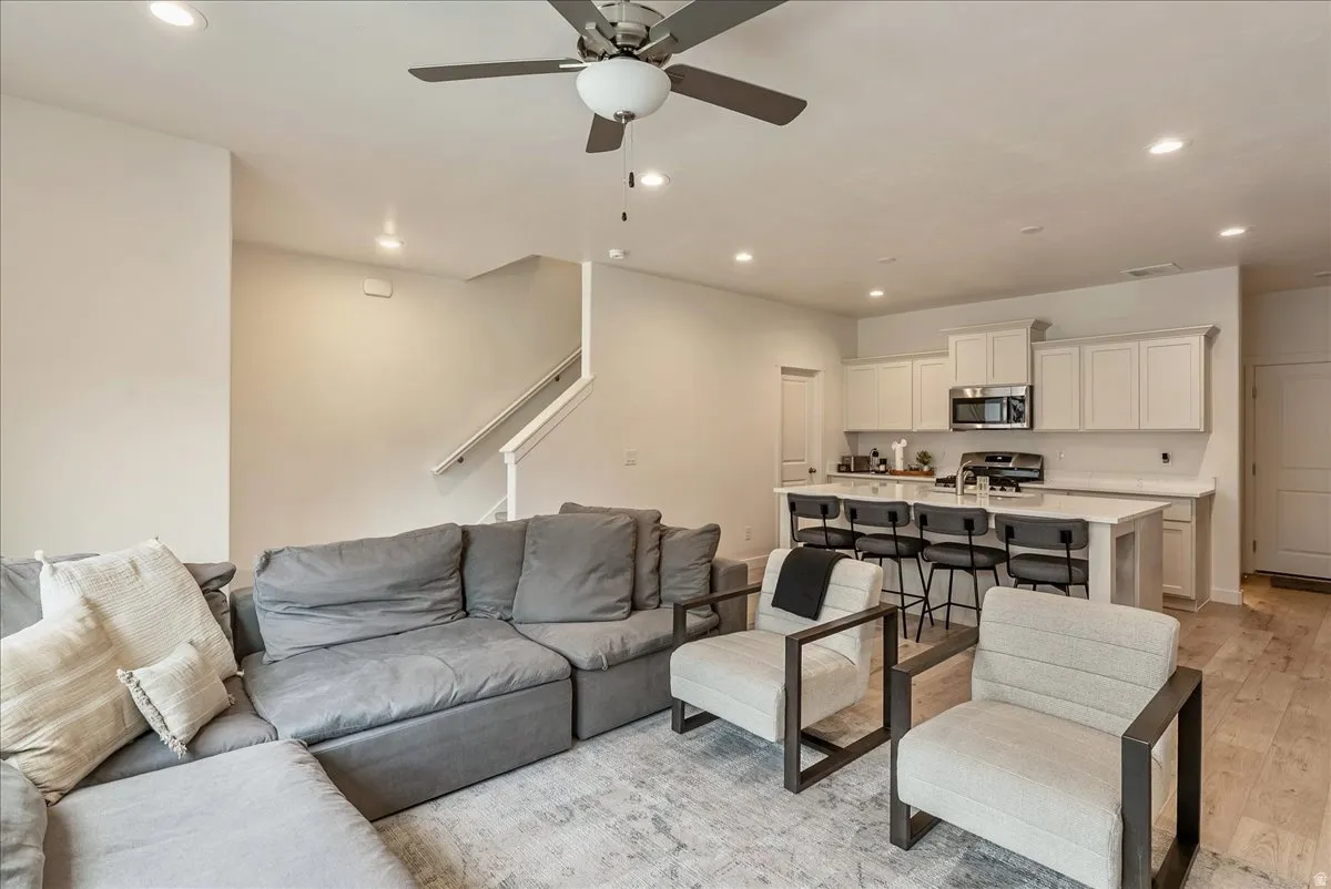 Open-concept living space featuring wood-finish flooring, recessed lighting, and a ceiling fan